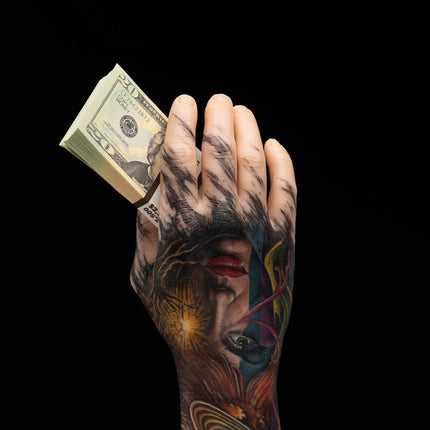 Tattooed hand holding cash