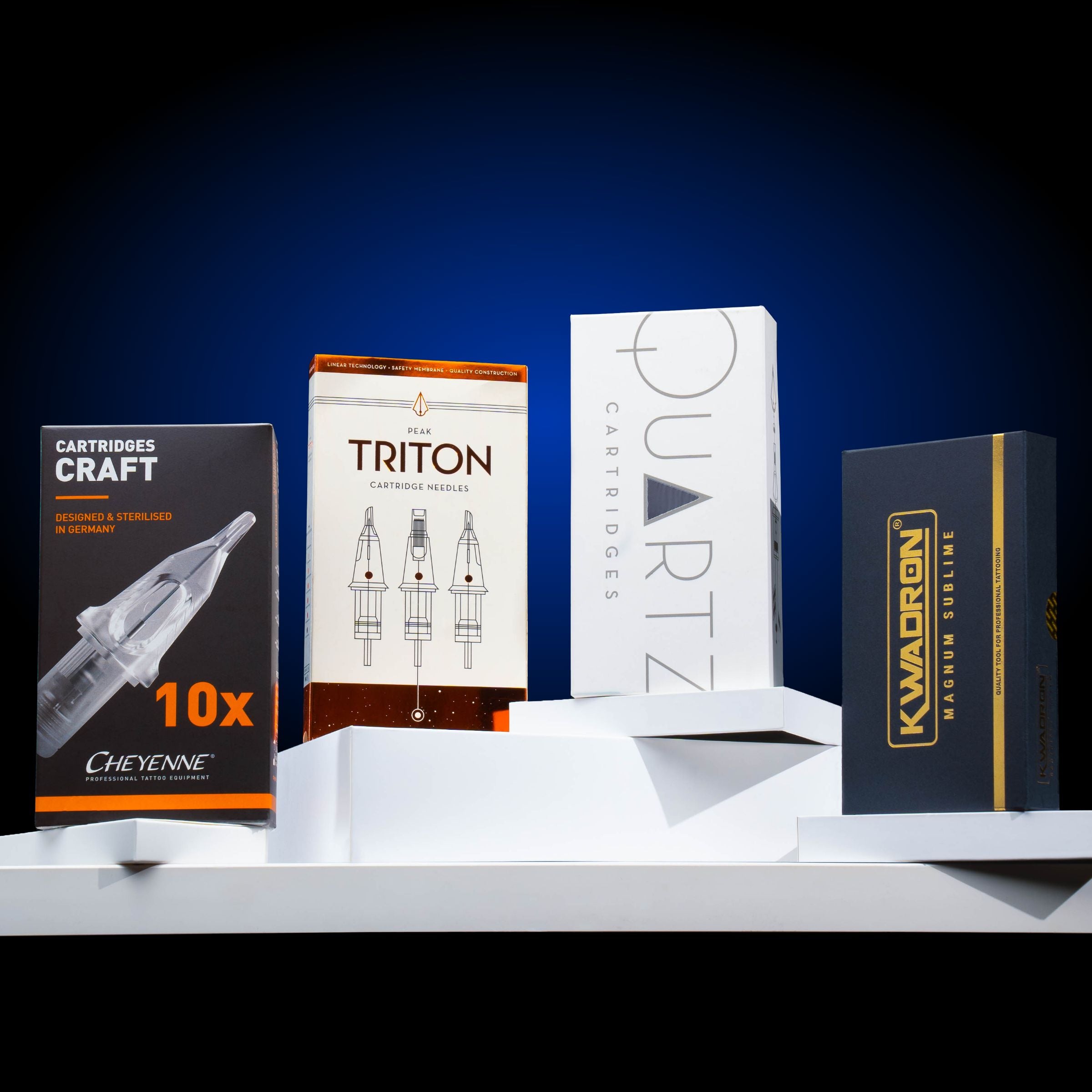 Box of Peak Triton cartridge needles, Cheyenne Craft cartridge needles, Peak Quartz cartridge needles, and Kwadron cartridge needles all on a table Your Complete Guide to Tattoo Needles: Types, Sizes & Uses