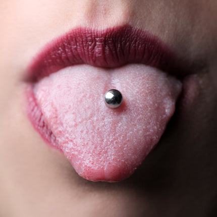 Close-up of a tongue piercing with a silver barbell.