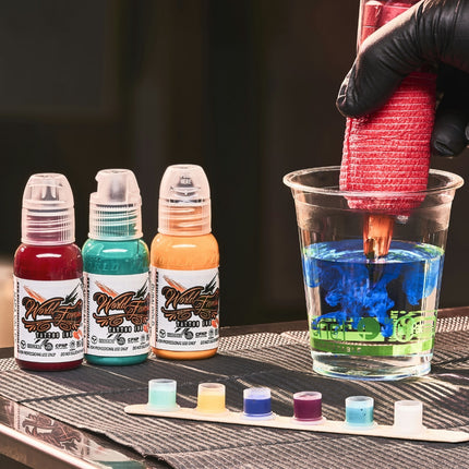 Close-up of tattoo artist setup with three World Famous tattoo inks and a cup of rinse water