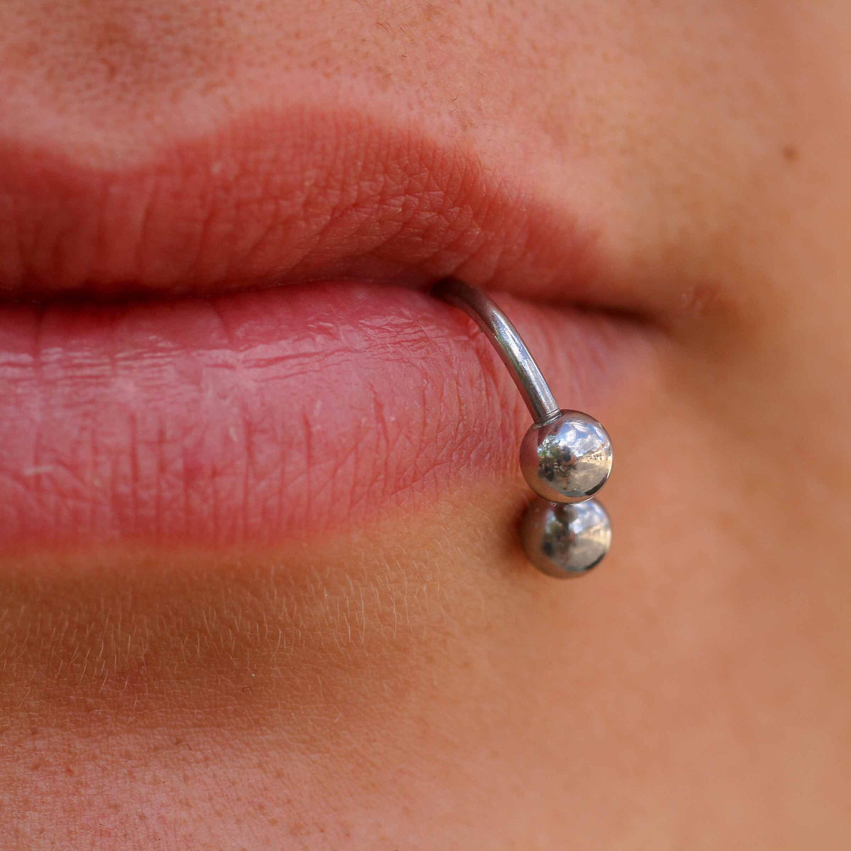 Closeup of bottom lip piercing with jewelry