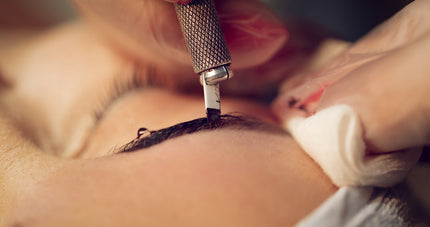 Microblading needles in PMU process on woman's brows