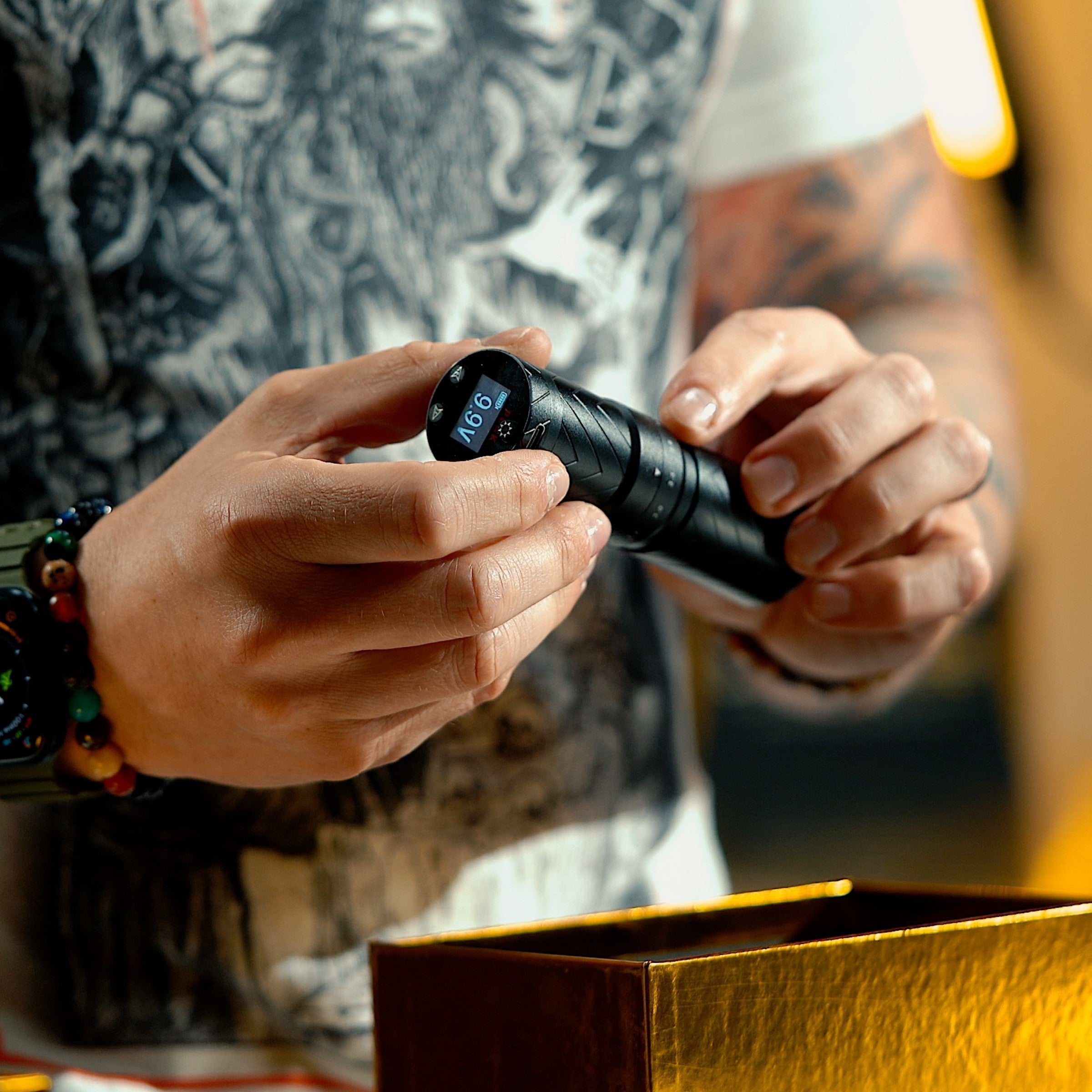 Close up of artist holding a Peak machine Choosing the Right Adjustable Stroke Tattoo Machine