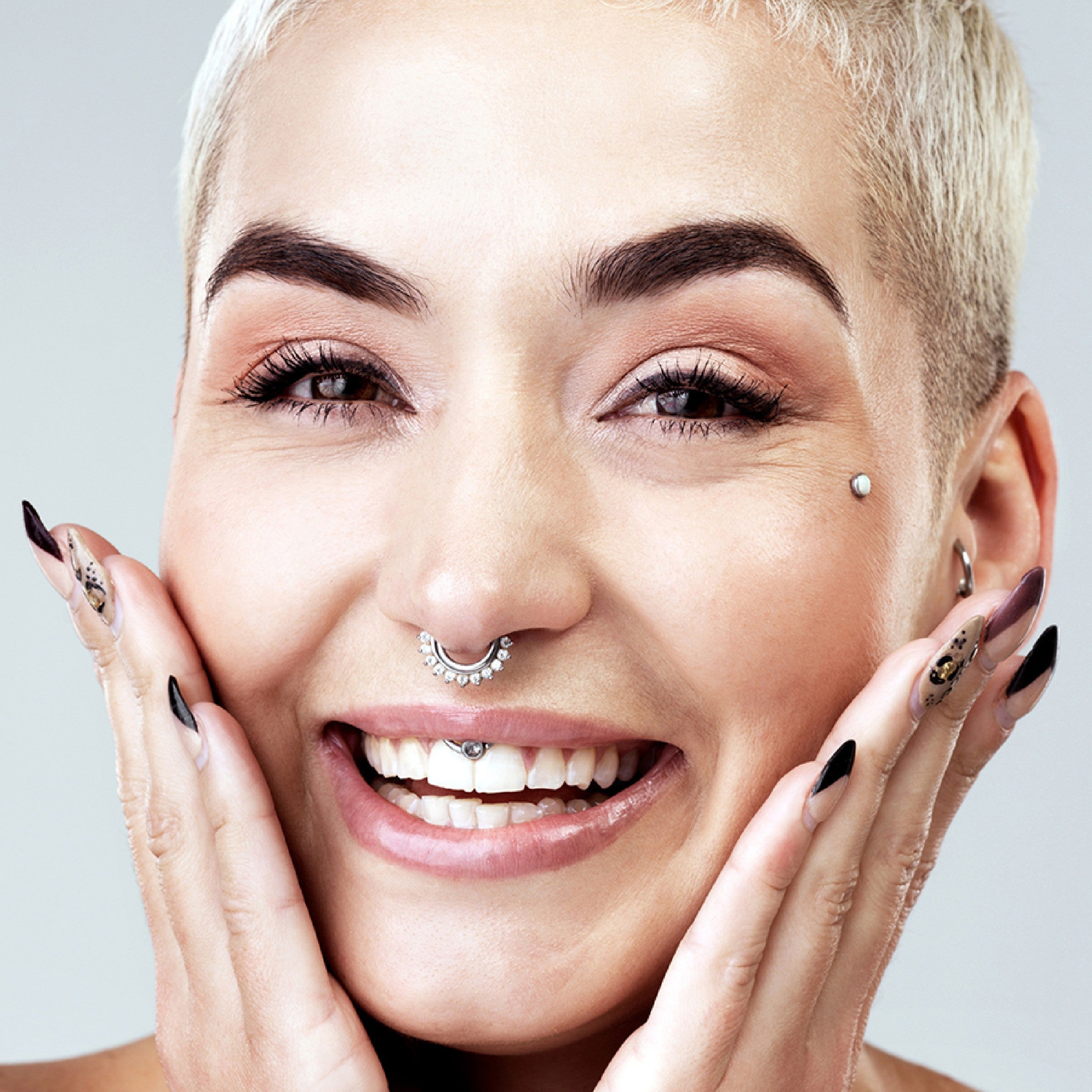 A person with a dermal piercing smiling. What Are My Dermal Jewelry Options?