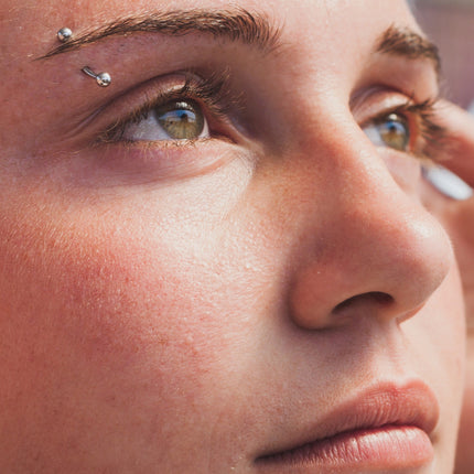 A woman with a brow piercing looking upward.|Girl With Eyebrow Piercing, Lip Piercing, &amp; Nostril Piercings|Anti-Eyebrow Piercing Picture
