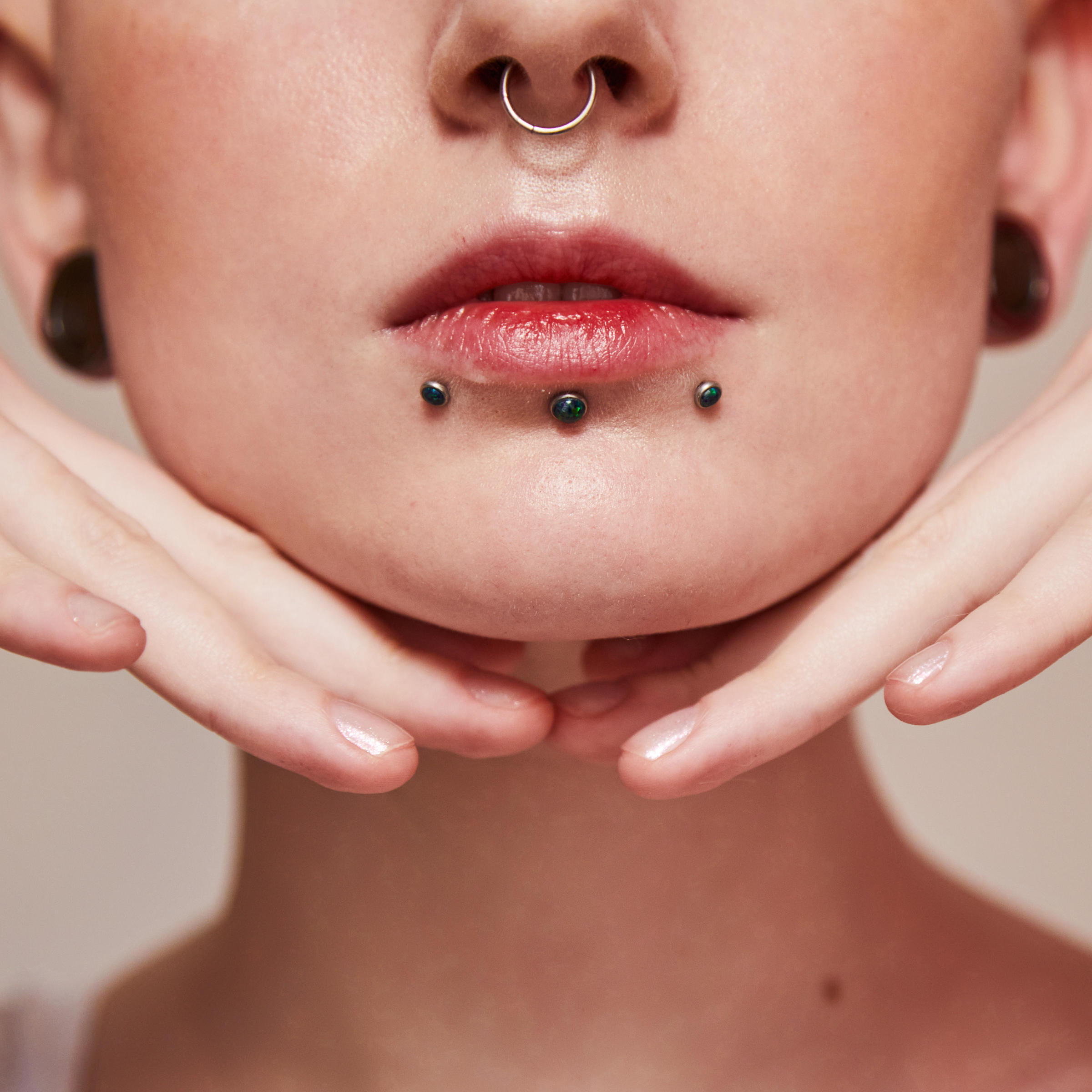 A woman with septum and labret piercings. Piercing Aftercare — What to Tell Your Clients