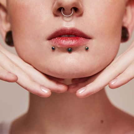 A woman with septum and labret piercings.