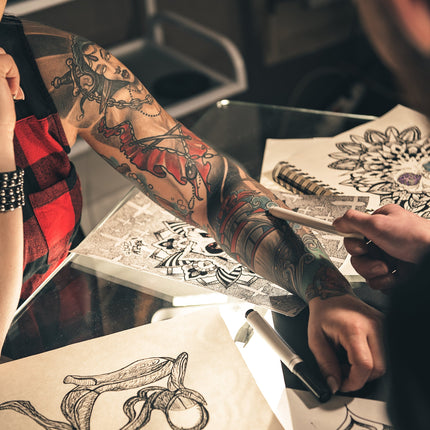 A full arm tattoo and various tattoo designs.
