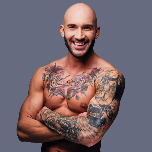 Fit tattoo artist with his shirt off covered in tattoos