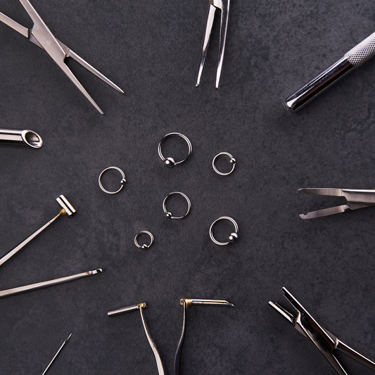 Circle of piercing tools and forceps around captive bead rings