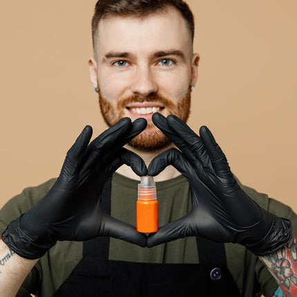 A tattoo artist holding a bottle of ink.