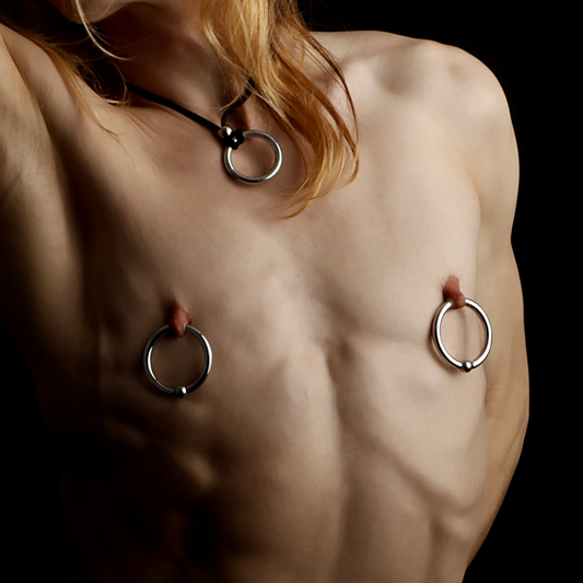 A man's bare chest and nipple piercings.