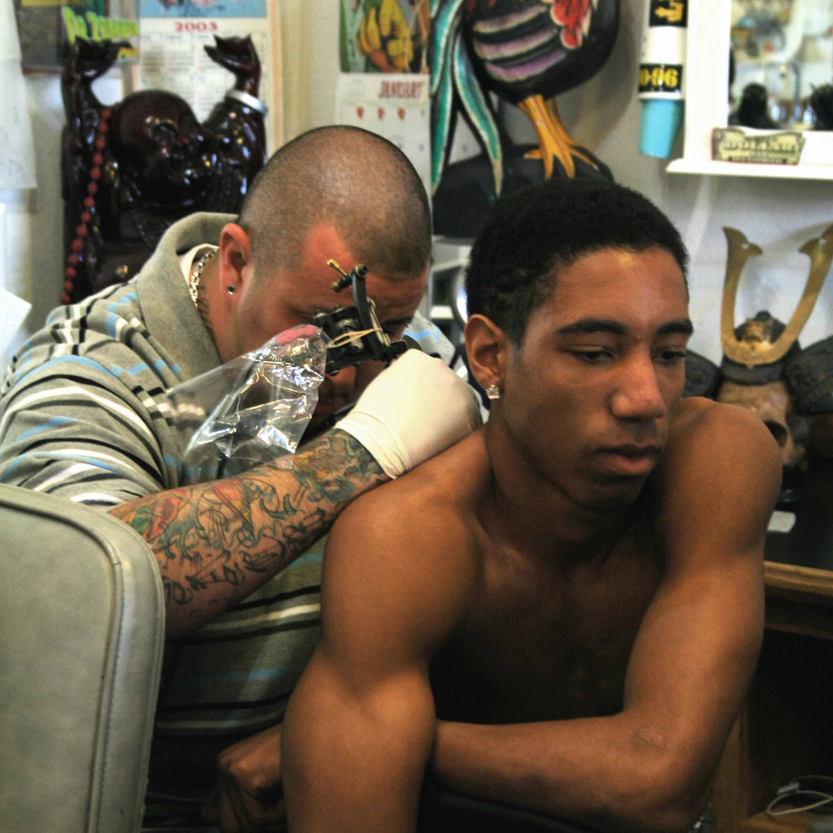 Black client getting a back tattoo