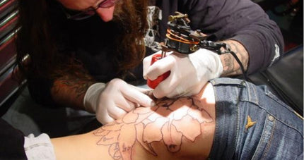 Man Tattooing Flowers on a Woman's Hip