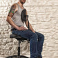 Precision Professional Tattoo Stool - Lifestyle Image Client Leaning Forward