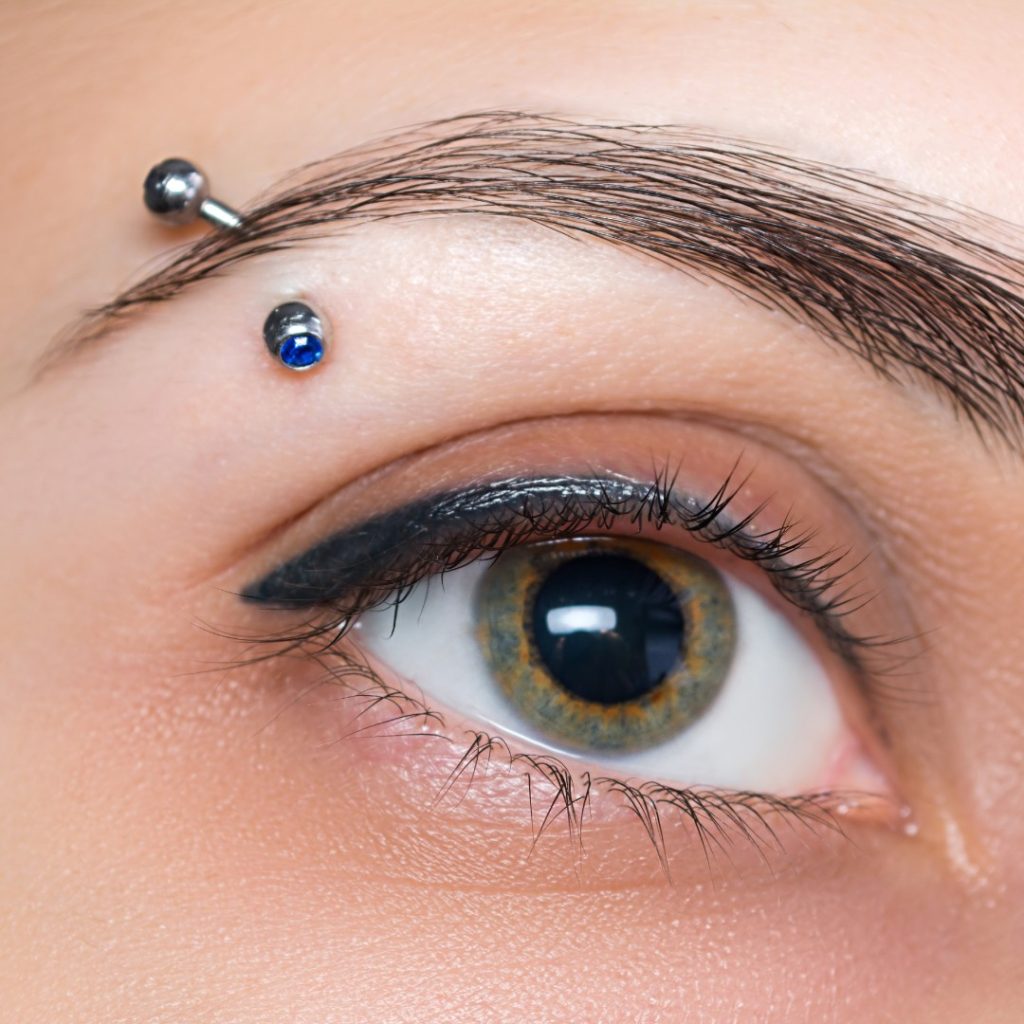 A single eyebrow piercing.