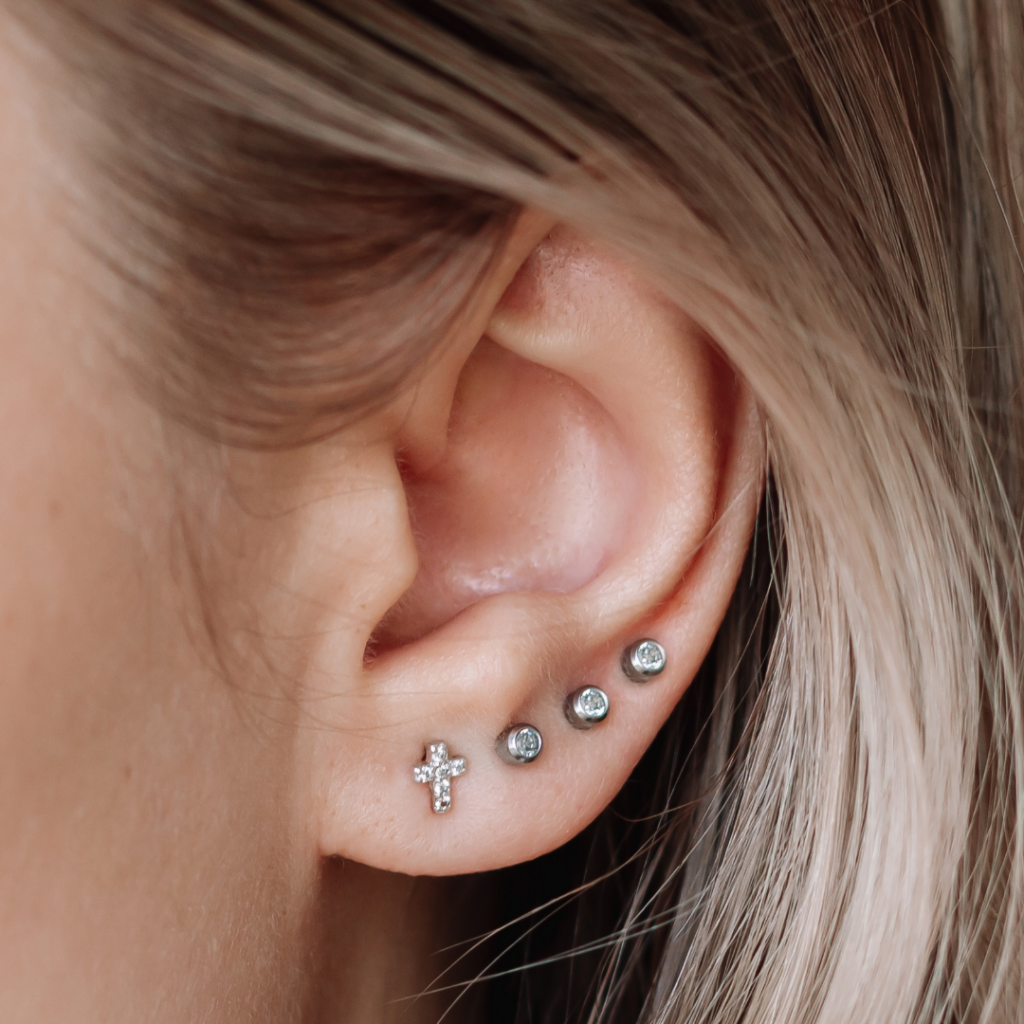Close-up of an ear lobe with stacked piercings