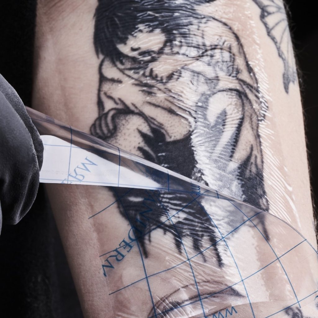 A Saniderm bandage removal from a healed tattoo.