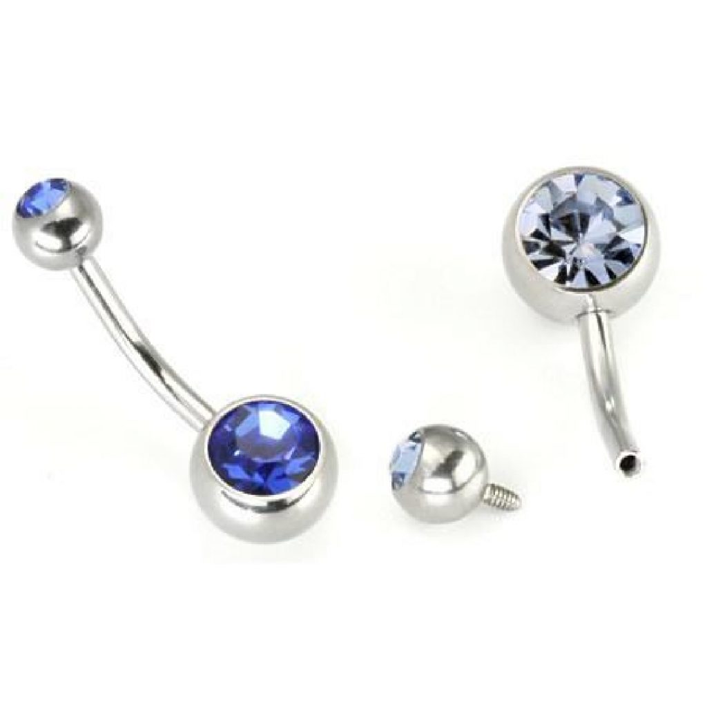 A disassembled belly button ring with blue gemstones.
