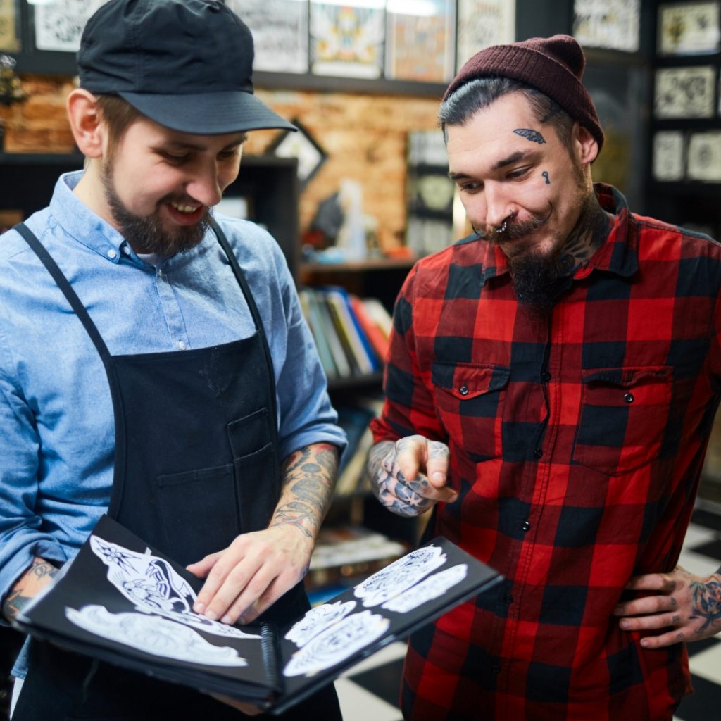 Tattoo artist and tattoo client going over different stencil options