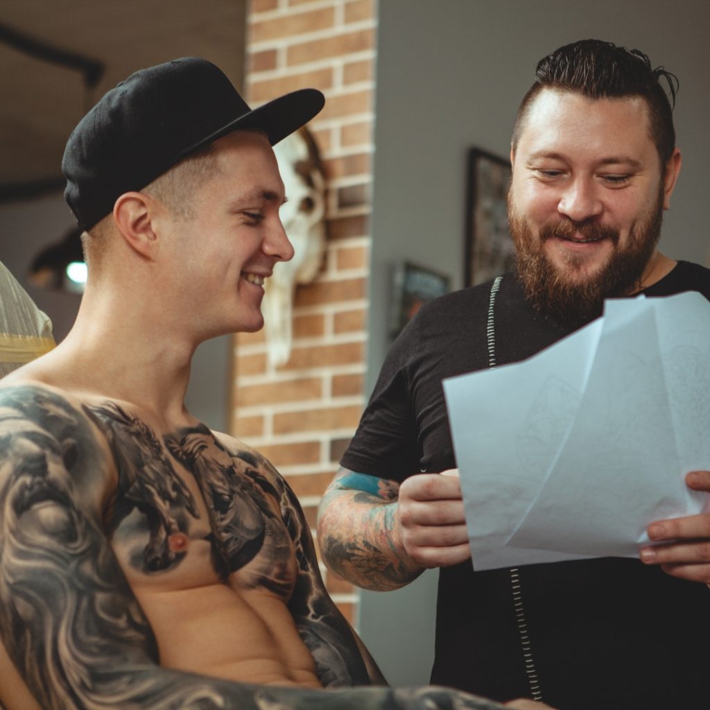 Tattoo artist and tattoo client chatting about expectations for a tattoo