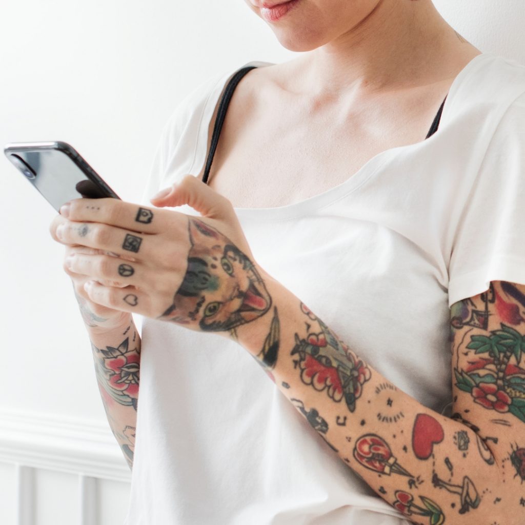 Tattoo artist using her phone to self promote on social media