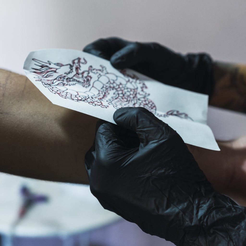 Tattoo stencil being applied by a tattoo artist