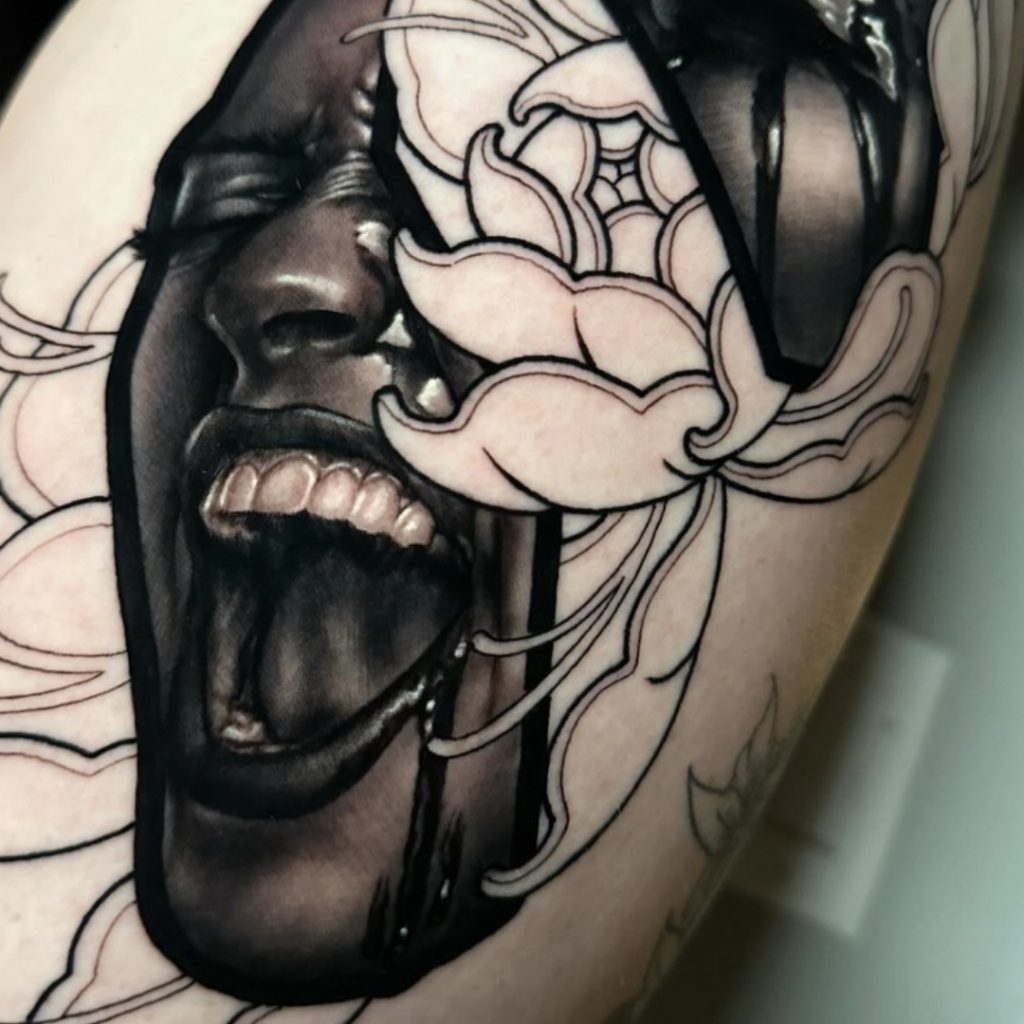 Shot of one of Harlan Kantner's mash-up tattoos featuring a lady head and neotraditional flower