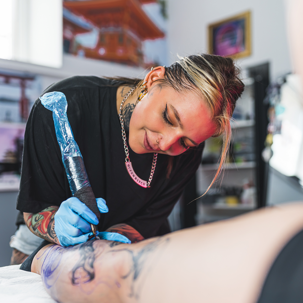Close-up of tattoo artist tattooing an arm