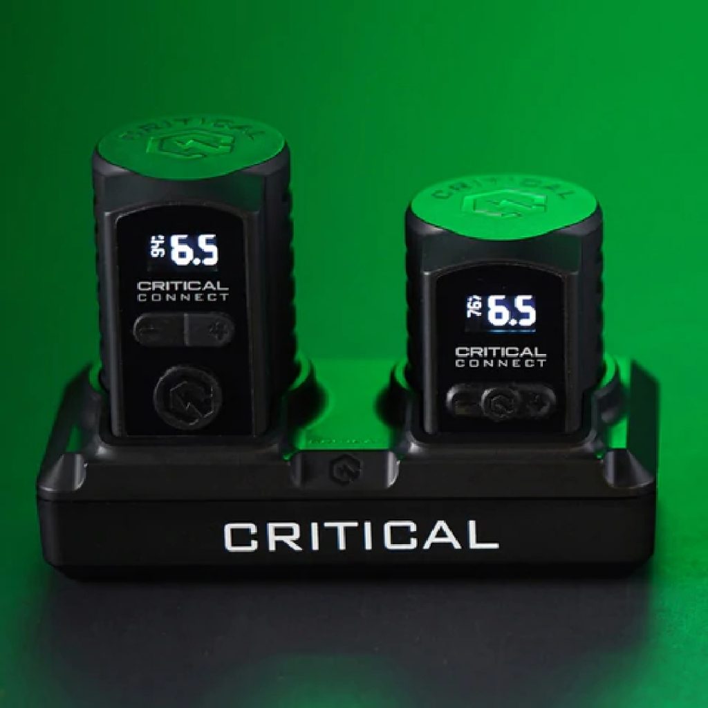 Two Critical battery packs sitting in a Critical charging dock