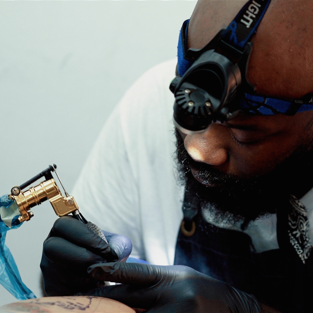 Tattoo artist Oba Jacksont attooing a client