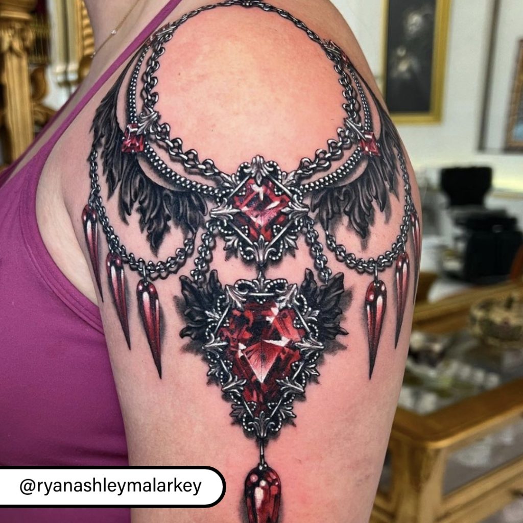Close-up of tattoo with red jewels by Ryan Ashley Malarkey