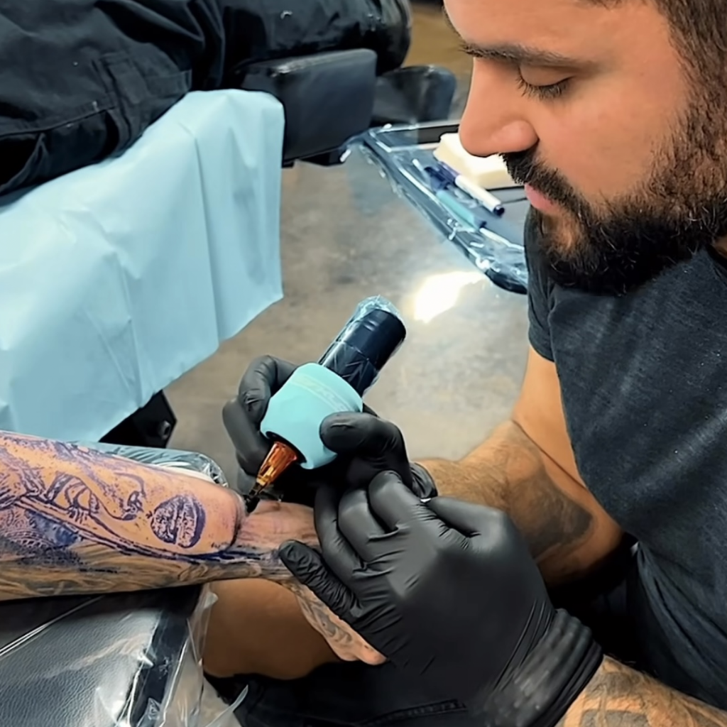 Close-up of tattoo artist doing a forearm tattoo with Peak Triton needle cartridges