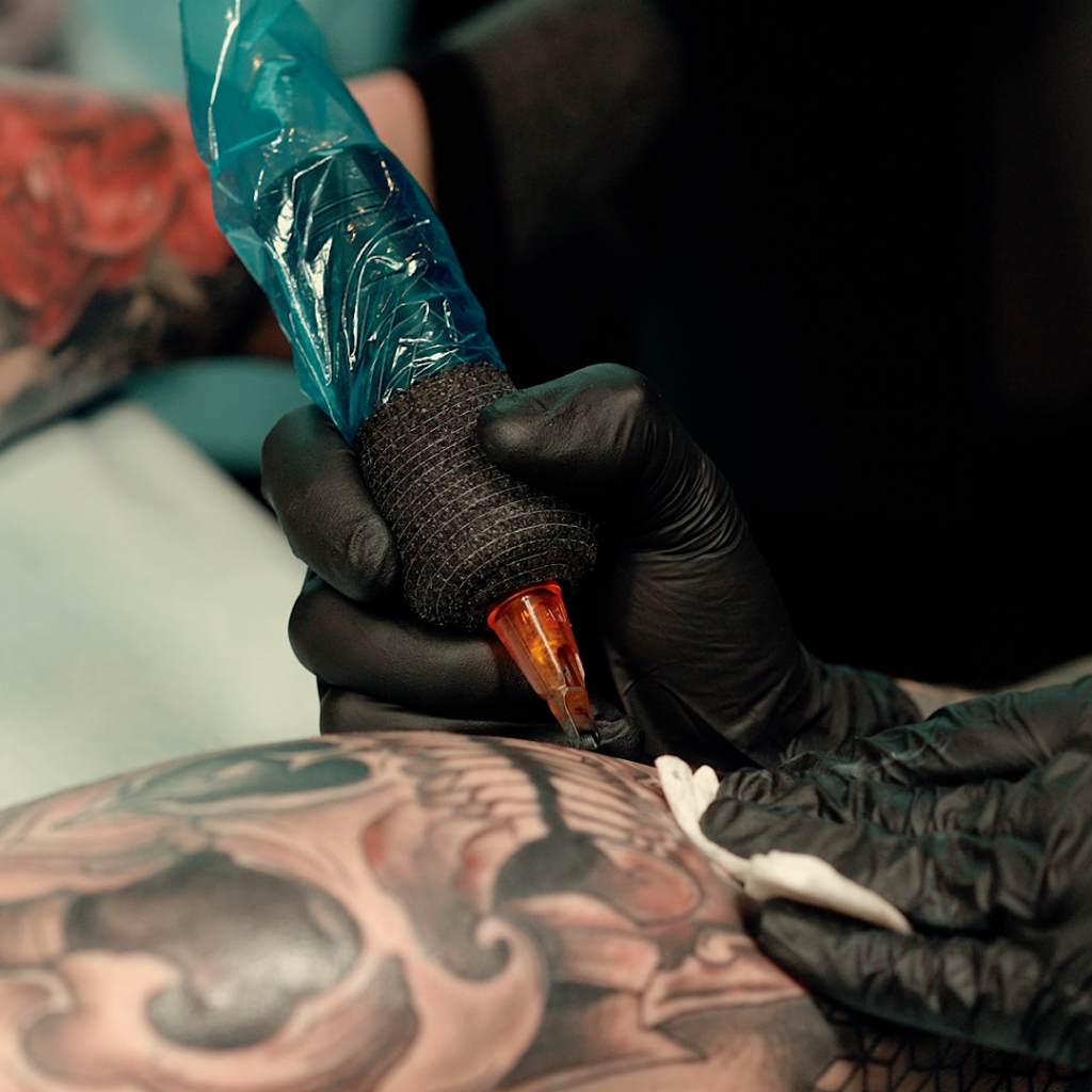 A man shading a skull tattoo.
