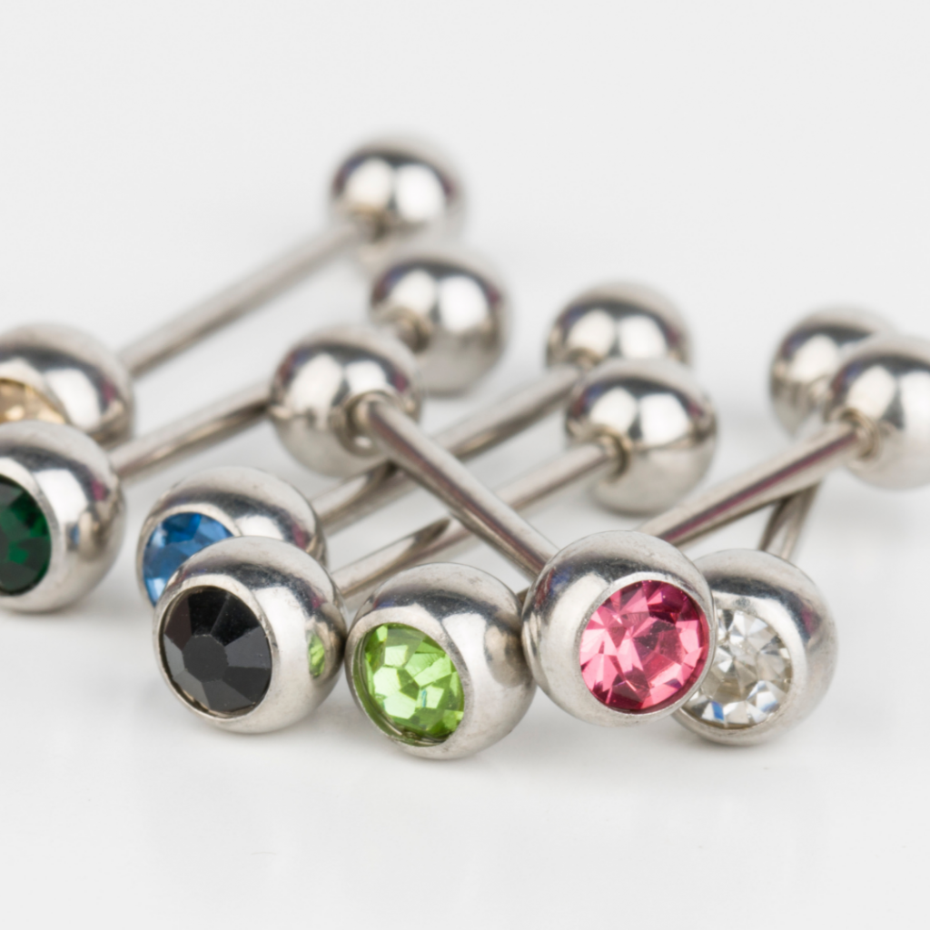 A cluster of barbell piercings with gemstones.