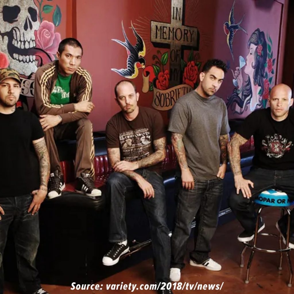 Various tattoo artists posing on set.